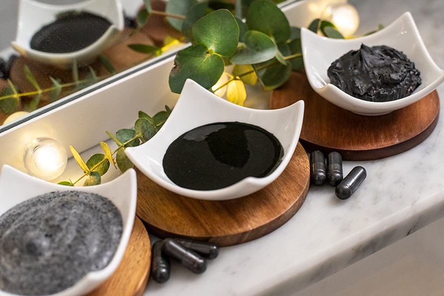 Tre skle med sorte ansigtsmasker indeholdende aktivt kul