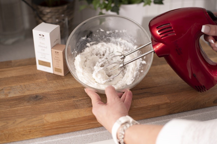 Body butter piskes med en elektrisk pisker i en skl.