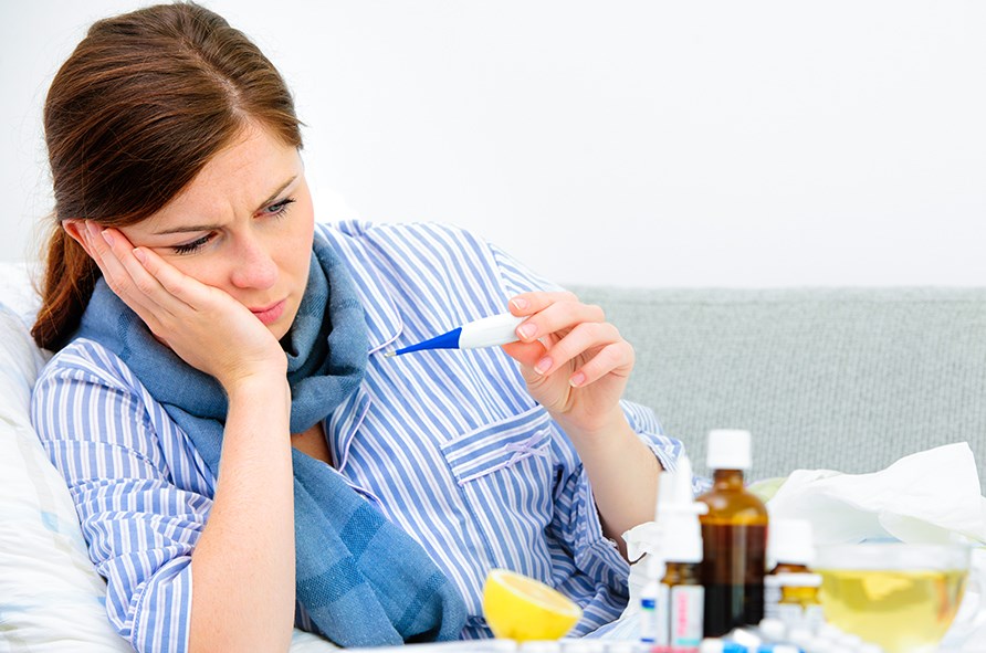 Kvinde med febertermometer i hånden. Kvinde med febertermometer i hånden.