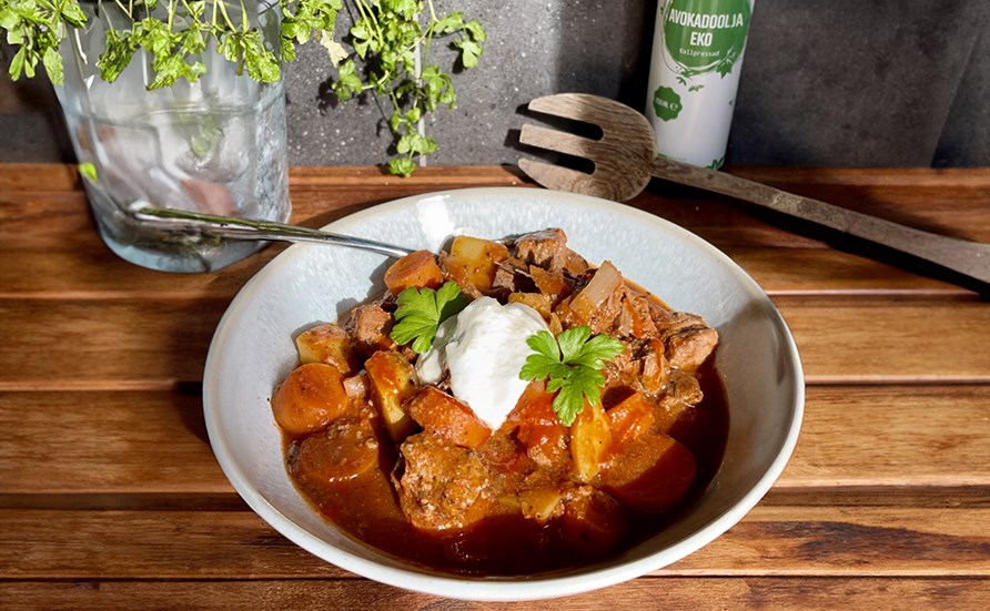 Gryde med k�d, kartofler, guler�dder, passata, hvidl�g og timian serveret p� en hvid tallerken.