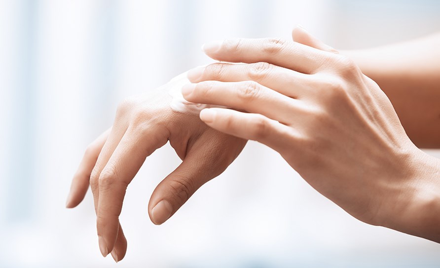 Hnder der smrer en hndcreme p huden.