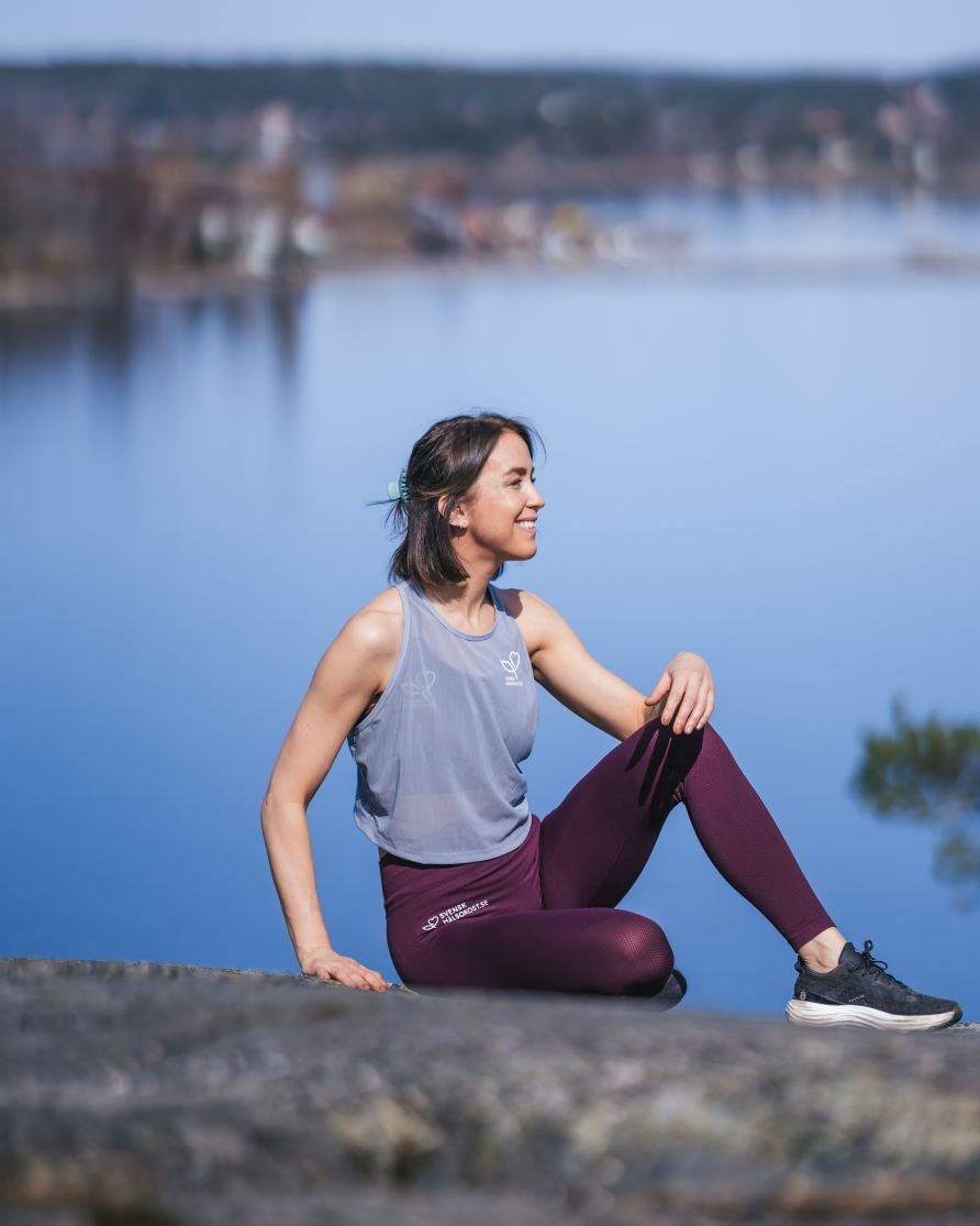 Sofia Sthl sidder p en klippe med udsigt mod vandet.