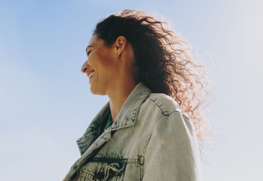 Leende kvinde ifrt cowboyjakke udendrs.