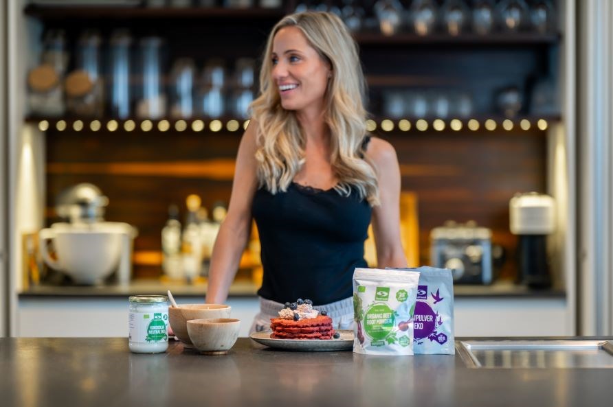 Lea Kessler st�r i et k�kken med pink vafler og ingredienser foran sig.