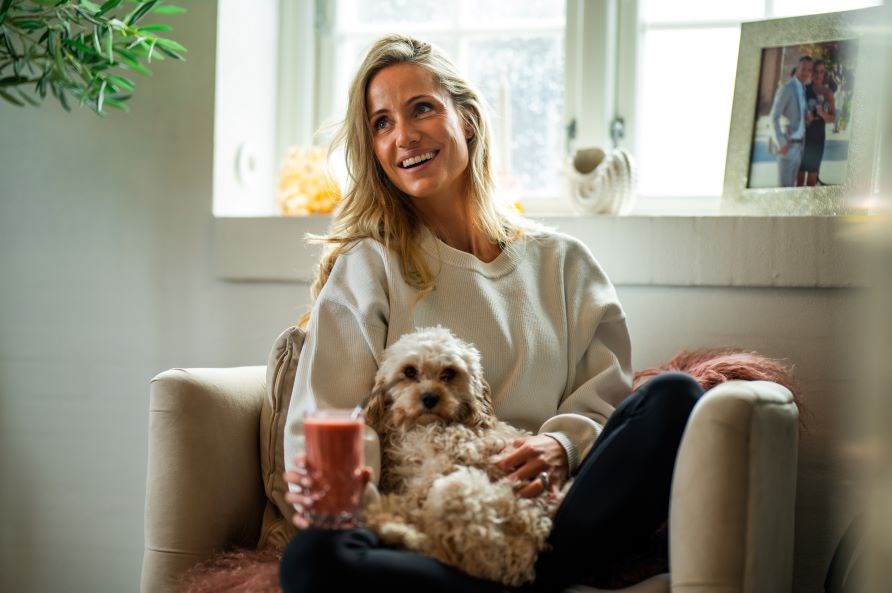 Lea Kessler sidder smilende i en l�nestol med en smoothie og en hund.