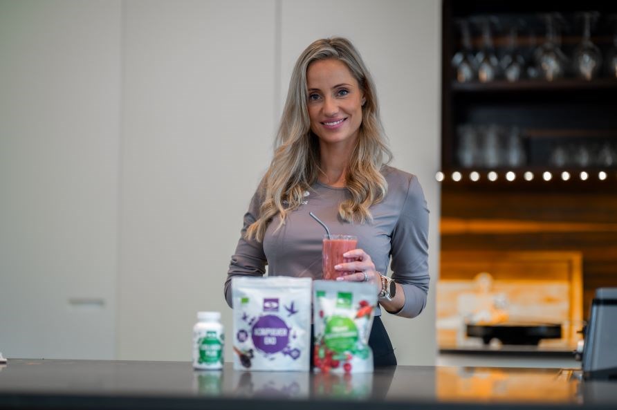 Lea Kessler st�r i et k�kken med en smoothie i h�nden foran nogle ingredienser.