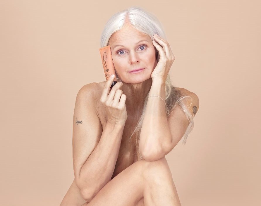 En kvinde, der holder en Lip Intimate Care-produkt mod ferskenfarvet baggrund. 