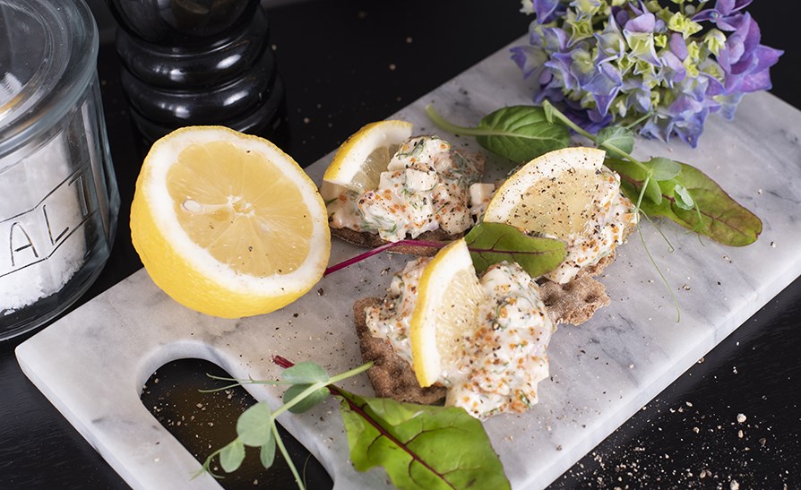 Vegansk rejesalat med citron p et skrebrt.