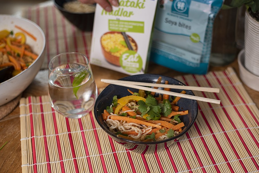 Vegansk wok serveret i en skl med spisepinde.