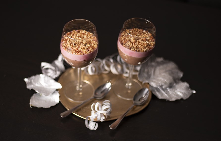 To vinglas med dadelmousse toppet med ndder str p et bord.