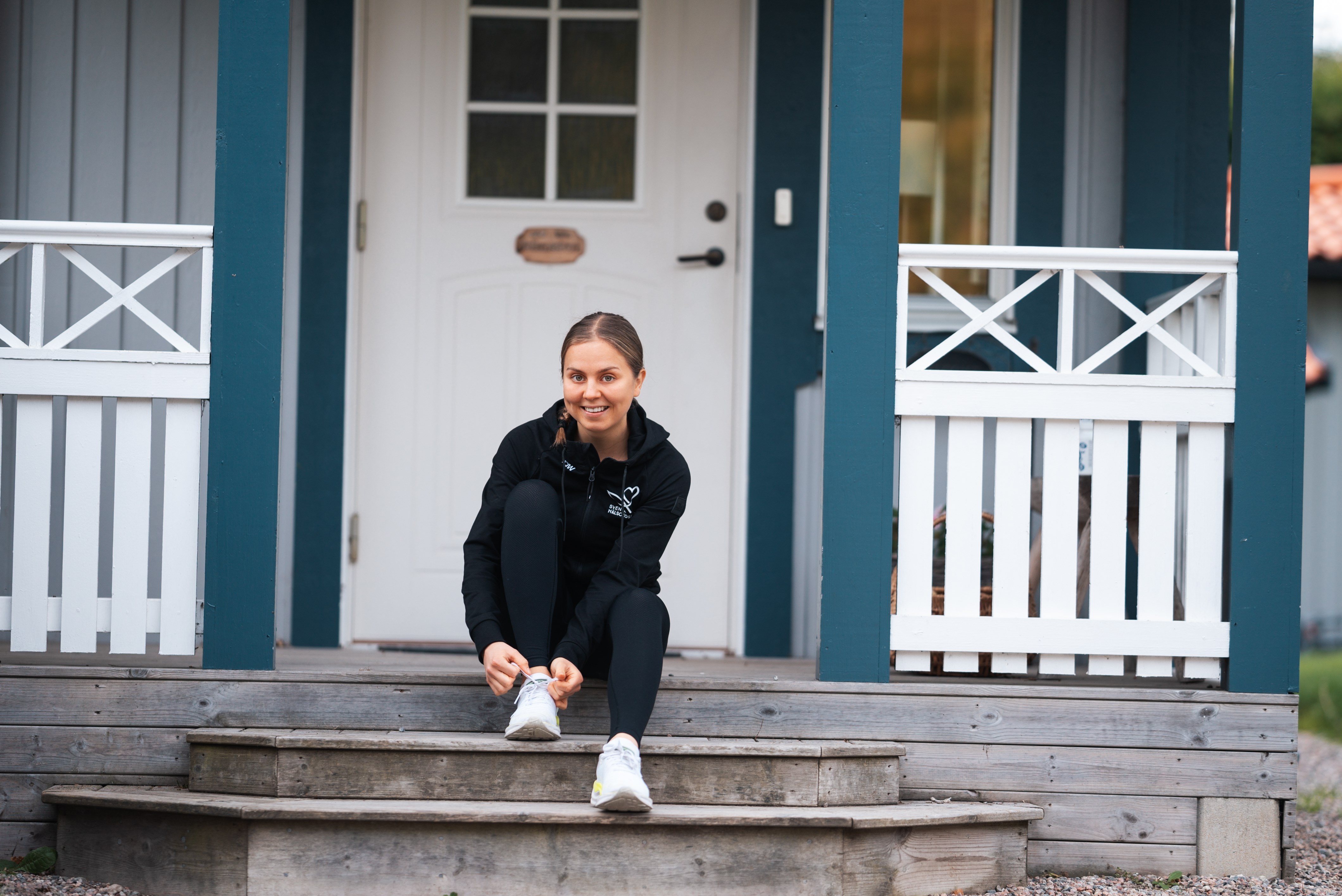 Josefine snrer sine lbesko mens hun sidder p en trappe, der frer op til en villa.