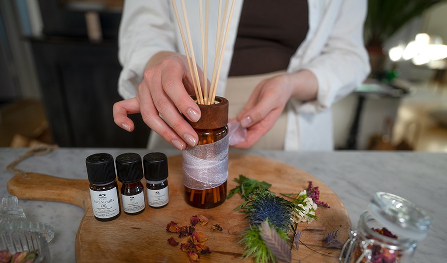 En kvinde str og er ved at pynte hjemmelavet duftpinde.