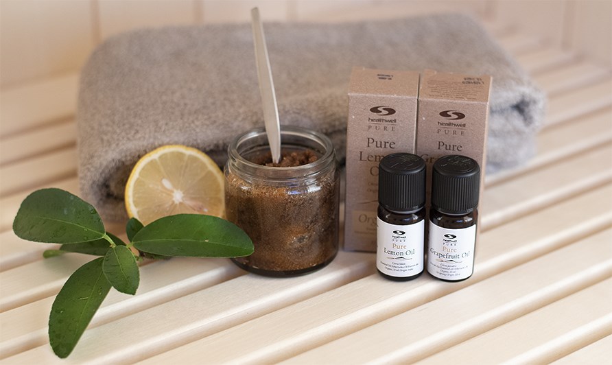 Hovedbundsscrub i et glas ved siden af teriske olier.