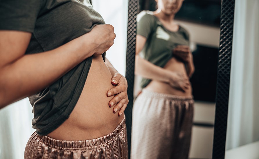 En kvinde holder hendes oppustet mave, med smerter. En kvinde holder hendes oppustet mave, med smerter.