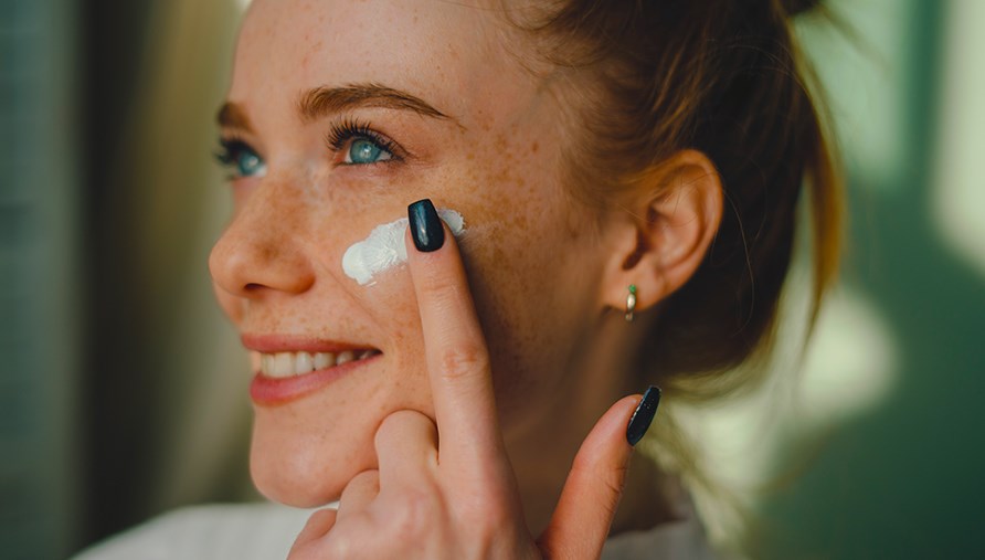 Kvinde smører ansigtet med ansigtscreme. Kvinde smører ansigtet med ansigtscreme.